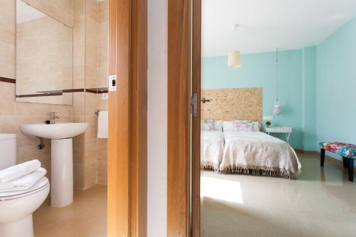 La salle de bains est pourvue d'une chambre avec un lit et des toilettes. dans l'établissement Apartamentos Alberto Lista 9, à Séville