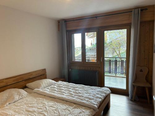 a bedroom with a bed and a large window at Apartment Veysonnaz near Ski Lift 4 Vallées in Veysonnaz
