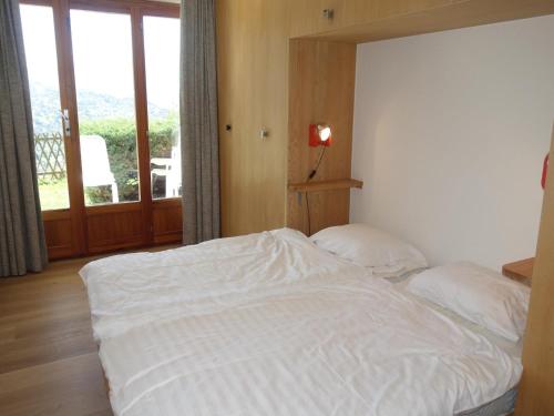 a bedroom with a white bed and a balcony at Apartment in Veysonnaz with Private Balcony in Veysonnaz