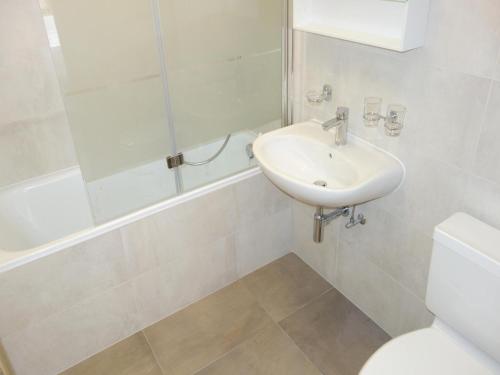 a white bathroom with a sink and a toilet at Apartment in Veysonnaz with Private Balcony in Veysonnaz