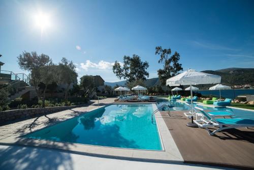 basen z leżakami i parasolami w ośrodku w obiekcie Lavender Cove w mieście Korfos