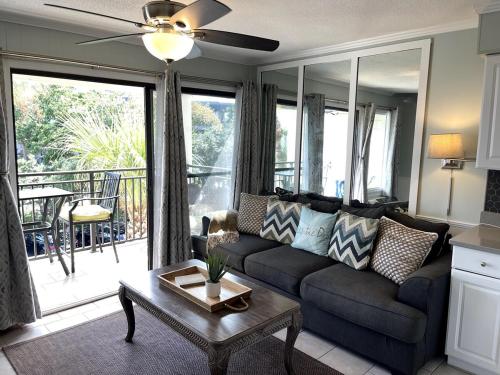 a living room with a couch and a table at Life is Better Oceanside Retreat-Coligny-#233 in Hilton Head Island