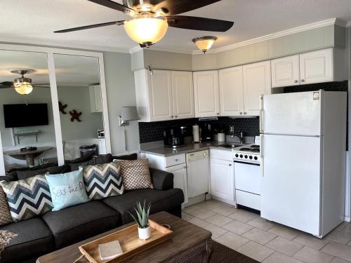 a living room with a couch and a white refrigerator at Life is Better Oceanside Retreat-Coligny-#233 in Hilton Head Island