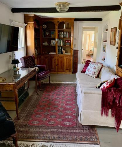 a living room with a white couch and a red rug at Charming 4BR colonial close to downtown in Keene