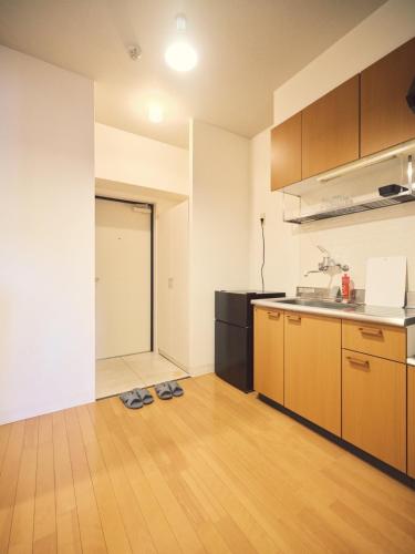 an empty kitchen with two pairs of shoes on the floor at vetta kumamoto sakuramachi 702 in Kumamoto
