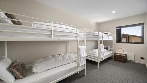 a bedroom with two bunk beds and a window at Burramungee - 5 Bedroom Chalet in Mount Hotham