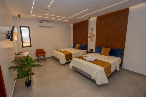 a hotel room with two beds and a plant at Blue Marlin Galápagos, Hotel & SPA in Puerto Baquerizo Moreno