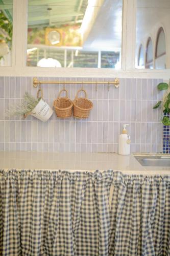 a kitchen counter with baskets on the wall at Ban Suanlum in Bangkok