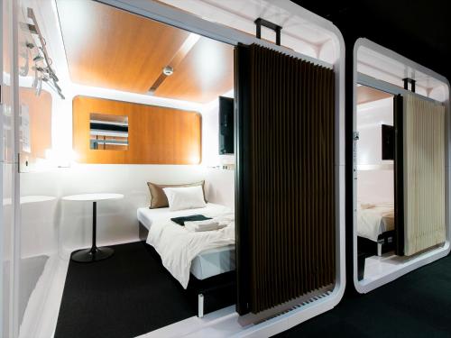 a small room with a bed and a table at First Cabin International Hawaii in Honolulu