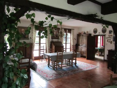 a living room with a table and chairs and a piano at B&B El Tyu in Écaussinnes-dʼEnghien