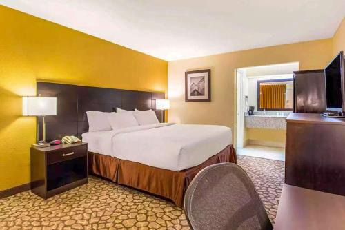 a hotel room with a bed and a television at Ramada by Wyndham Santee I-95 in Santee