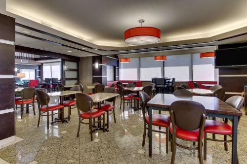a dining room with tables and chairs in a restaurant at Heritage Inn Suites Houston Sugar Land, Trademark by Wyndham in Sugar Land