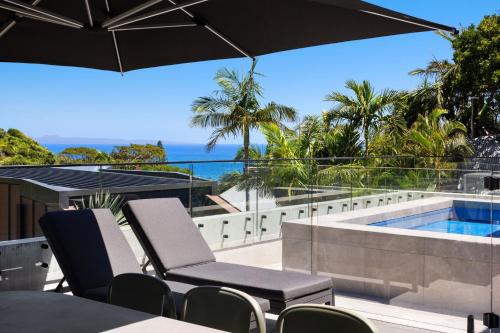 un patio al aire libre con sillas y una piscina en Solar Eclipse, en Byron Bay