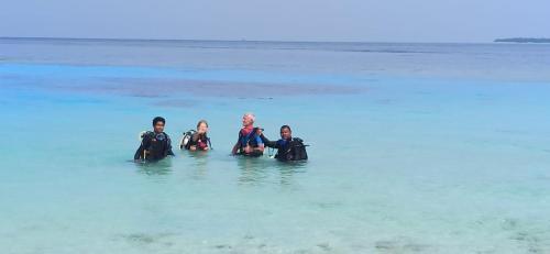 a group of people sitting in the water at Liberty Guesthouse Maldives in Mahibadhoo