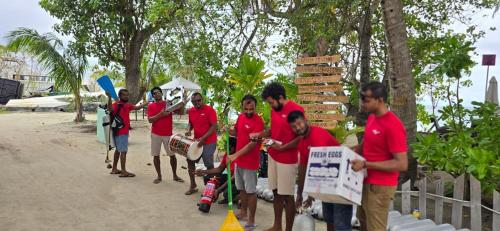 a group of men in red shirts standing together at Liberty Guesthouse Maldives in Mahibadhoo