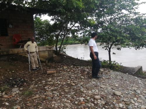 two men standing outside of a house near a river at Bioparque Las Cañadas in Mocoa