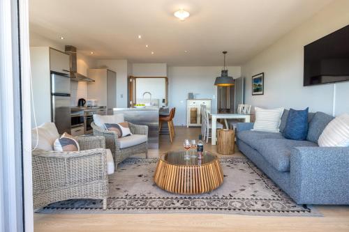 a living room with a couch and a table at The Sands - Apartment 5 - Stay Waiheke in Onetangi