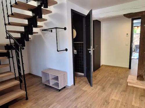 a living room with stairs and a stair case at Charmante maisonnette entre forêt et détente avec spa et WIFI - FR-1-589-786 in Ville-sur-Illon