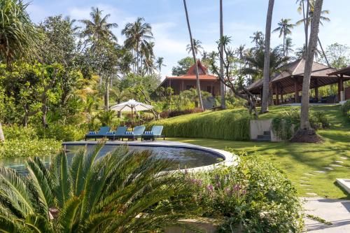 a resort with a pool and chairs and trees at Villa Ronggo Mayang at Balian beach in Antasari
