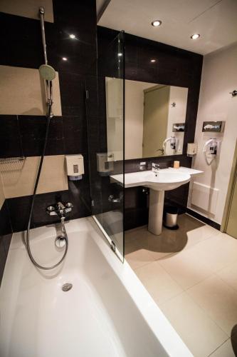 a bathroom with a bath tub and a sink at Le Pietri Urban Hotel in Rabat