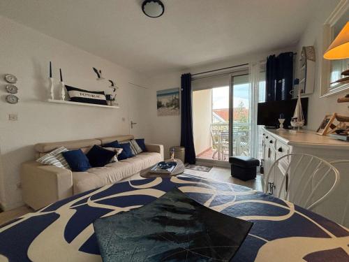 un salon avec un canapé et une table dans l'établissement Appartement 2 pièces à Royan/Pontaillac avec balcon et parking - FR-1-494-203, à Royan