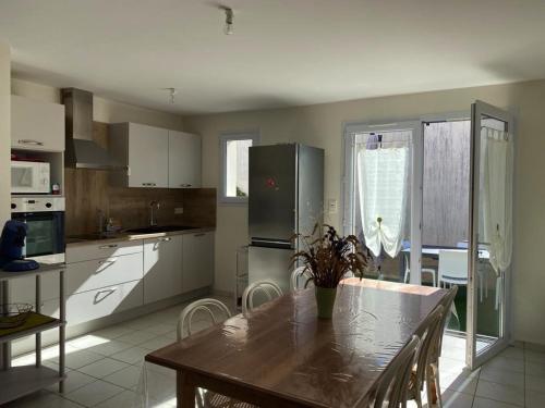 une cuisine avec une table et un réfrigérateur dans l'établissement Villa agréable à 700m de la plage - FR-1-336-161, à Longeville-sur-Mer