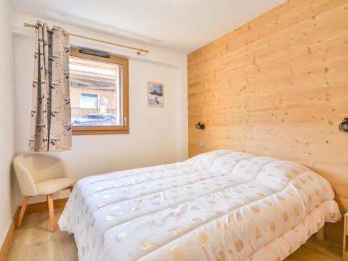 une chambre avec un lit, une fenêtre et une chaise dans l'établissement Duplex 8 pers moderne, centre Morzine, proche télécabines - FR-1-684-69, à Morzine