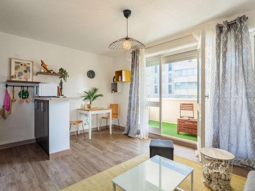 un salon avec une table et une fenêtre dans l'établissement Studio moderne avec balcon et parking à Biarritz - FR-1-3-625, à Biarritz