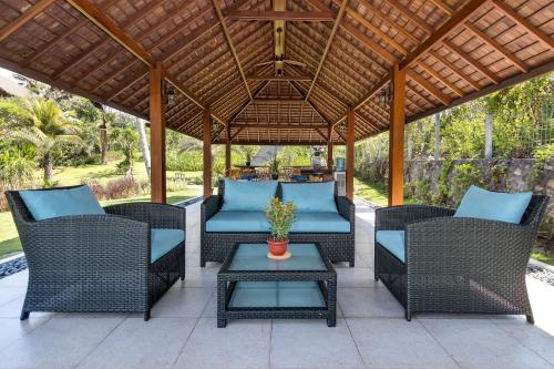 a patio with wicker chairs and a table at Villa Ronggo Mayang at Balian beach in Antasari
