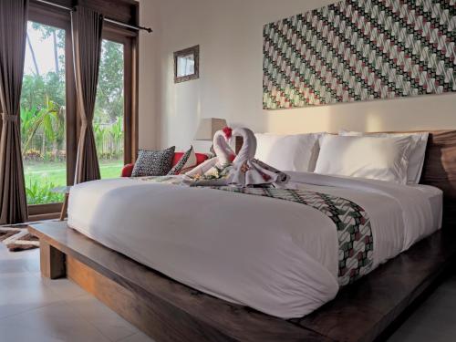 a bedroom with a large bed with swans on it at Villa Ronggo Mayang at Balian beach in Antasari