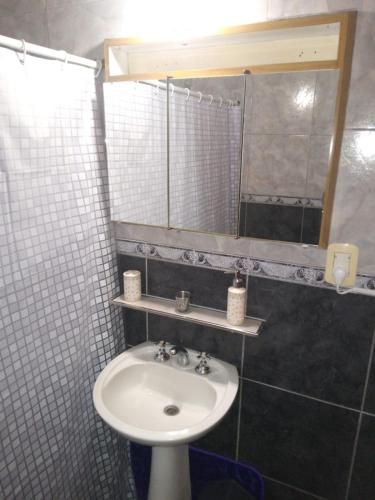 a bathroom with a sink and a mirror at Alojamiento EL DESCANSO in Olavarría