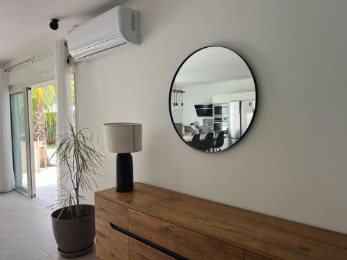 a mirror on a white wall in a living room at Villa Tropéa in Les Cocos
