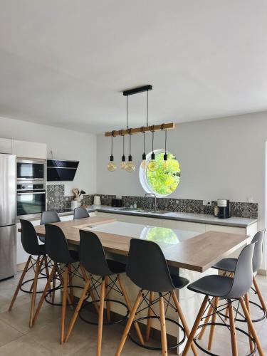 a kitchen with a wooden table and chairs at Villa Tropéa in Les Cocos