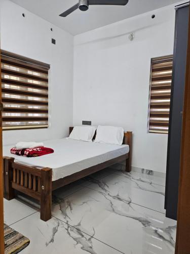 a bed in a white room with marble floors at MetroNova Homes - Furnished stay in Ambalappuzha in Alleppey