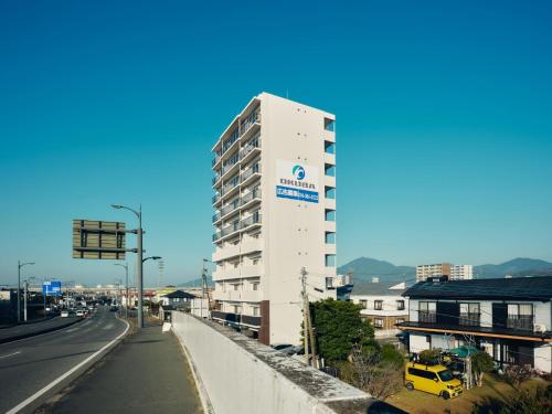 a tall white building on the side of a road at intro vetta 1003 Free parking in Kumamoto