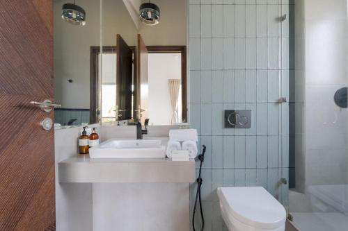 a bathroom with a sink and a toilet and a tub at La Olalian 2 & 3 BHK Designer Villas Near Anjuna Beach with Private Pool & Sun Deck & Garden in Anjuna