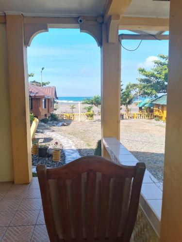 a view of the ocean from a porch with a chair at Seabreeze Beachfront Home and Cottages new management in San Juan