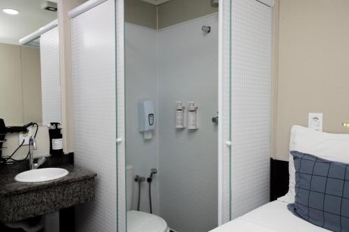 a bathroom with a shower and a toilet and a sink at Hotel Aero Sleep Campinas in Campinas
