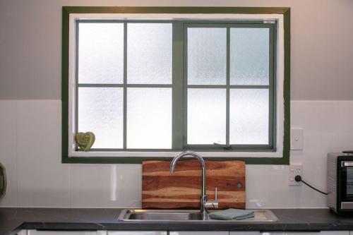 a kitchen sink with a window above a counter at DaVic in Athenree