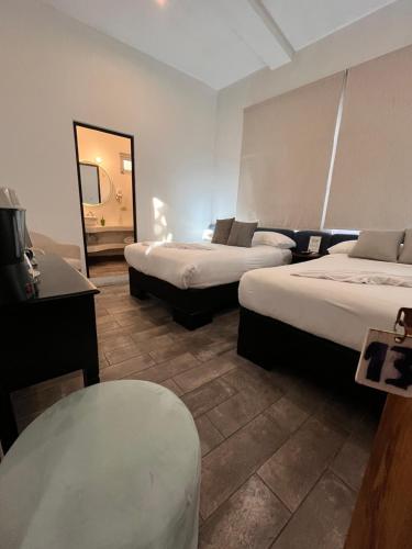 a hotel room with two beds and a mirror at Grupo Hotelero Colibri in Panajachel