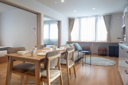 a dining room with a table and chairs at TKD HOUSE Furano 2 in Furano