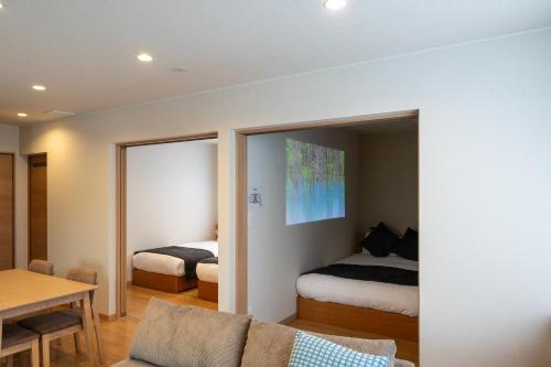 a living room with a bed and a couch and a bedroom at TKD HOUSE Furano 2 in Furano