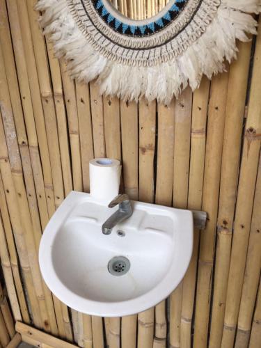 a bathroom sink with a mirror on a wooden wall at La Danu Glamping in Kubupenlokan