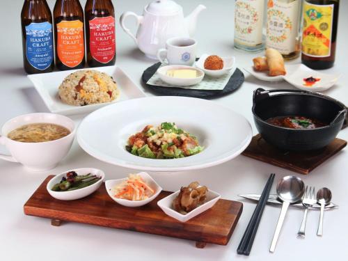 a table with plates of food and bowls of food at Pension Kobekko in Otari