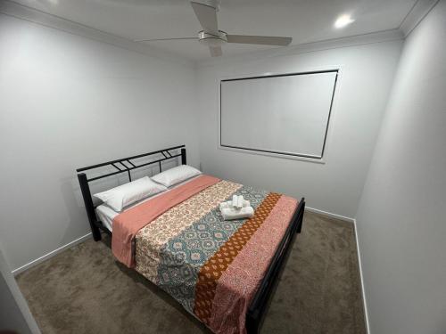 a bedroom with a bed with a blanket and a fan at Entire home in ParkRidge 4BedR 2BathR 3LivingR 8PP in Park Ridge