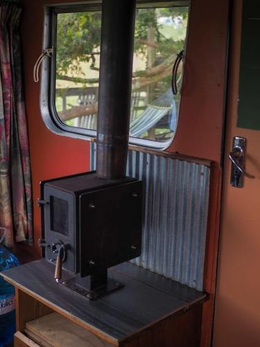 a stove sitting on a table next to a window at Down to earth NZ in Kerikeri