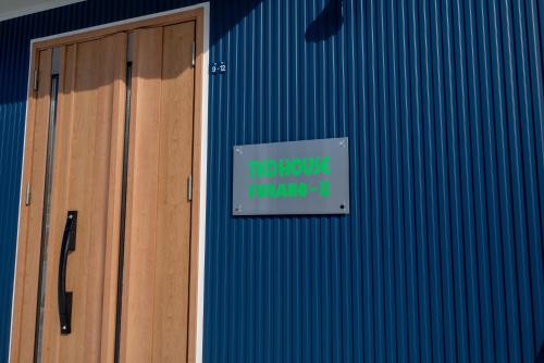 a sign on the side of a building with a door at TKD HOUSE Furano 2 in Furano