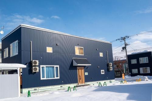 a black building in the snow at TKD HOUSE Furano 2 in Furano