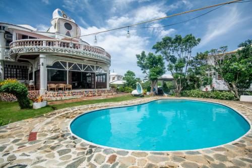 a swimming pool in front of a house at Casa de Arte in Boracay