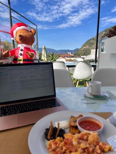 a teddy bear sitting on a table next to a laptop at Grupo Hotelero Colibri in Panajachel